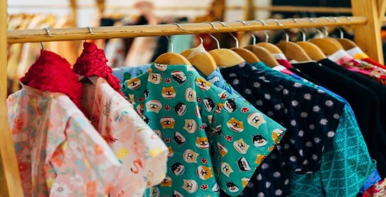 Rail of colourful secondhand patterned shirts on wooden hangers