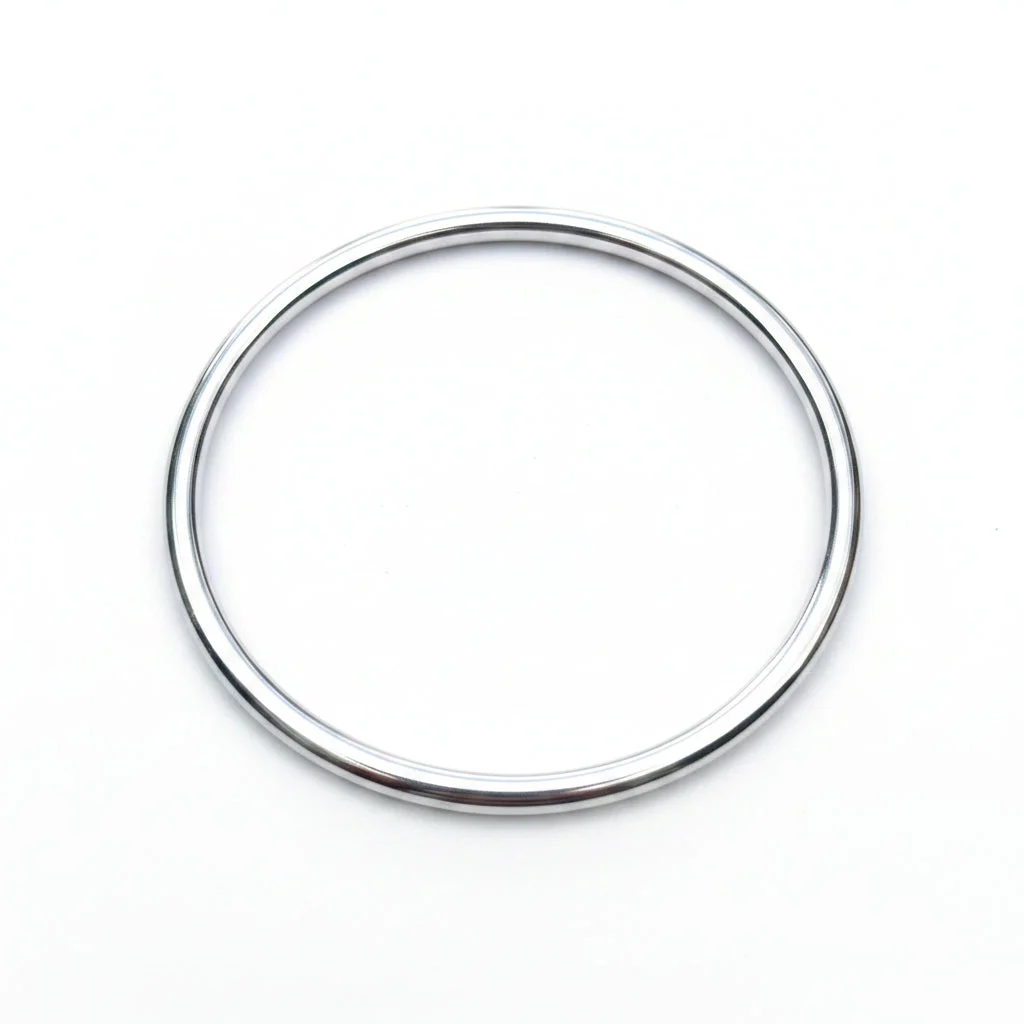 A polished silver metal bangle bracelet on a pale background.